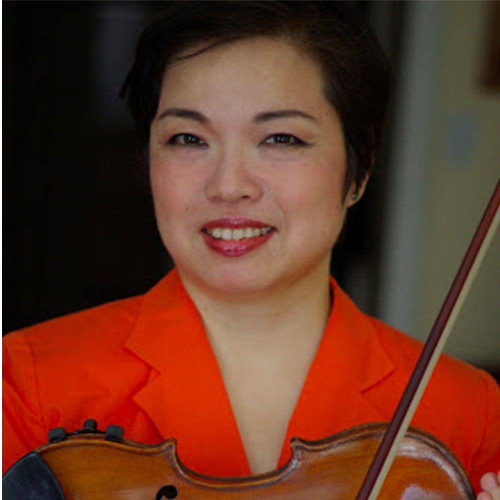 Photo of Mari Kimura holding a violin and wearing an bright orange blazer